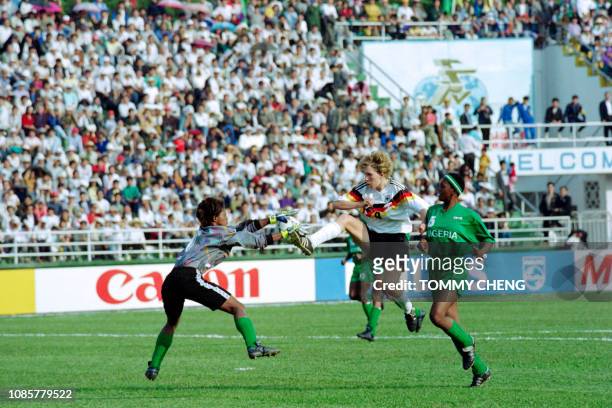 Nigeria goalkeepr Oyeka Anna Agumanu and Omon-Love Branch try to stop German Heidi Mohr's attack during the group C first match on November 17, 1991...