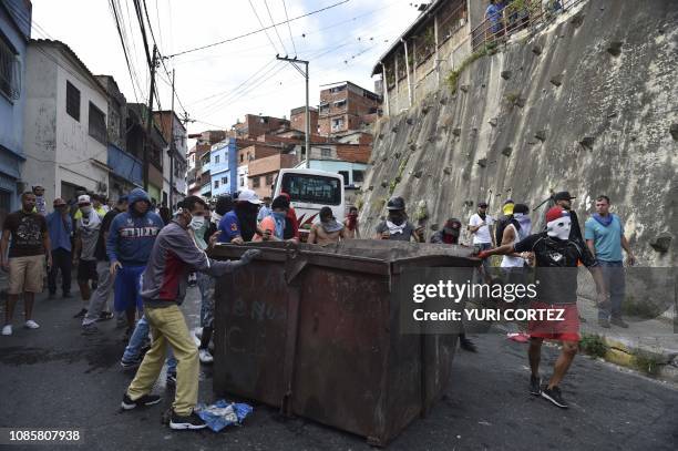 Anti-government demonstrators set a barricade during clashes with police and troops in the surroundings of a National Guard command post in Cotiza,...