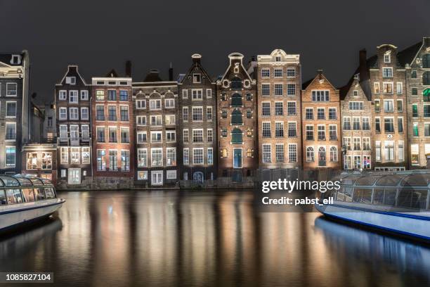 amsterdam skyline oude gebouwen waterkant damrak - amsterdam canal stockfoto's en -beelden