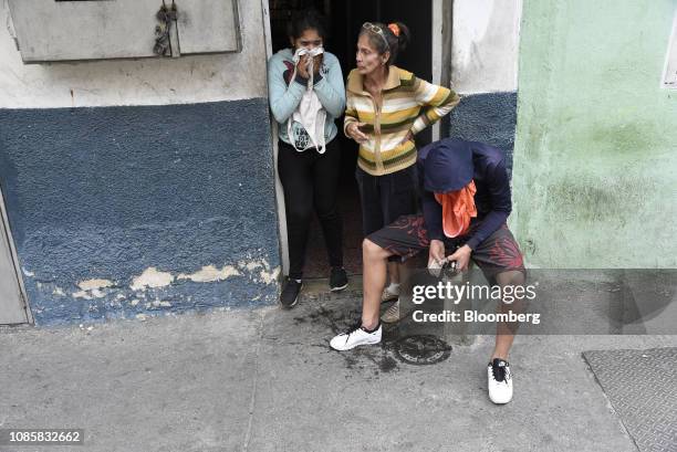 People affected by tear gas stand in a doorway during a protest in the Cotiza neighborhood of Caracas, Venezuela, on Monday, Jan. 21, 2019. A number...