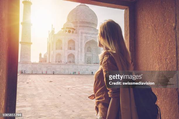 menina bonita de cabelo loiro, contemplando o nascer do sol no taj mahal na índia - agra - fotografias e filmes do acervo