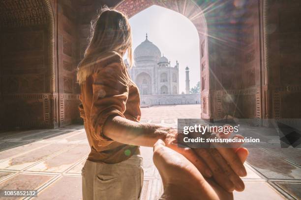 seguimi al taj mahal, india. turista donna che porta il fidanzato lì magnifico mausoleo famoso ad agra. concetto di viaggio per le persone - soggettiva foto e immagini stock