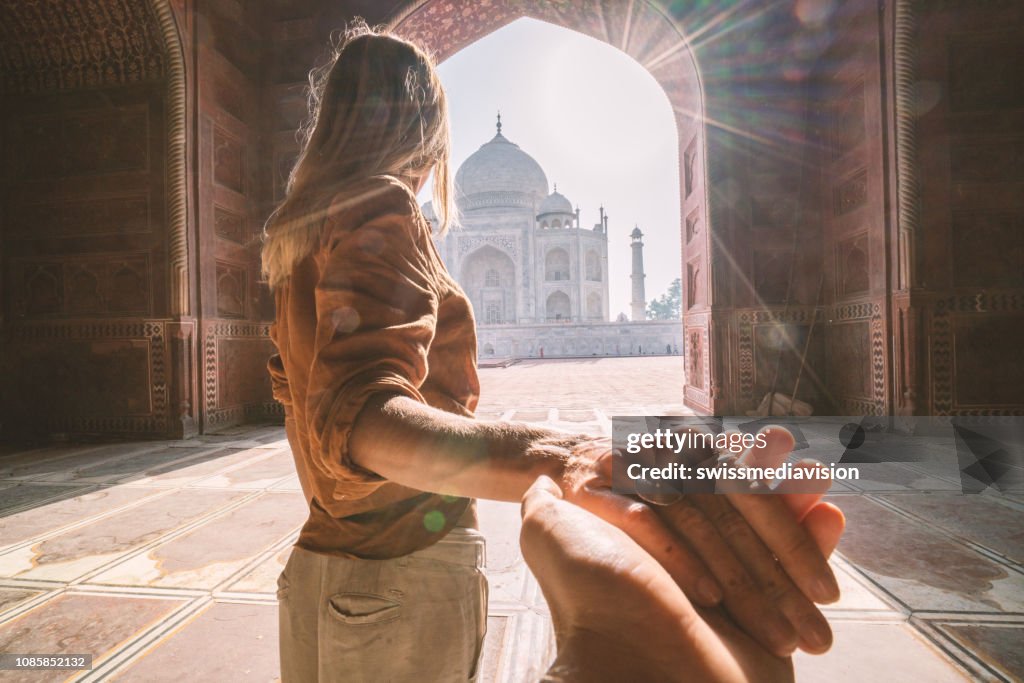 Follow me to the Taj Mahal, India. Female tourist leading boyfriend to there magnificent famous Mausoleum in Agra. People travel concept