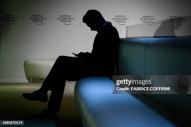 Visitor is seen in silhouette in the Congress Center ahead of the World Economic Forum 2019 annual meeting, on January 21, 2019 in Davos, eastern...
