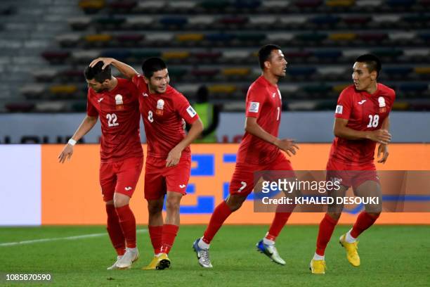 Kyrgyzstan's players celebrate their equalising goal during the 2019 AFC Asian Cup Round of 16 football match between UAE and Kyrgyzstan at the Zayed...