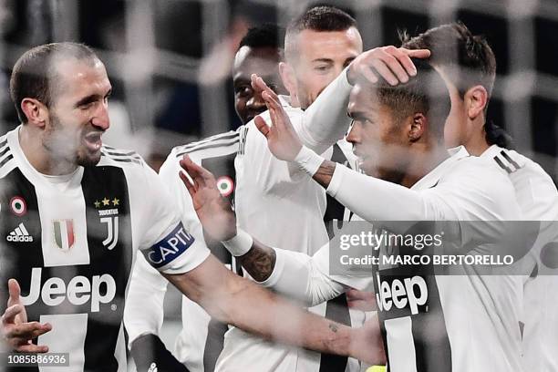 Juventus' Brazilian forward Douglas Costa celebrates with his teammates Juventus' Italian defender Giorgio Chiellini and Juventus' Italian forward...