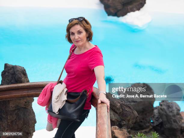 spanish ethnicity woman in summer posing for a photography close to the water.  island of lanzarote, canary islands, spain. - magenta stockfoto's en -beelden