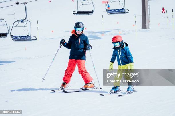 two boys dressed in ski clothes learning to ski - sierra nevada spain ski photos et images de collection