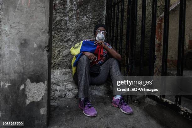 Female protester taking cover from tear gas during a protest against Nicolas Maduro. 27 Military officers of the National Guard were arrested after...