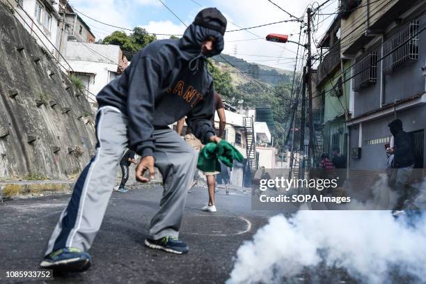 Protester is seen running towards a tear gas cannister during a protest against Nicolas Maduro. 27 Military officers of the National Guard were...