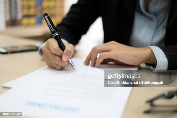 woman signing job contract - submission fotografías e imágenes de stock