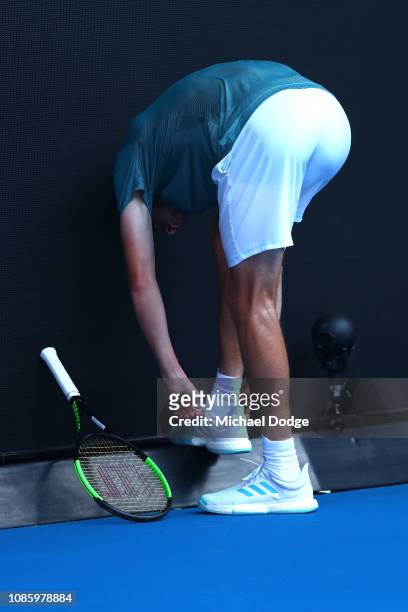 Stefanos Tsitsipas of Greece reacts puts his shoe back on after it came off during play in his quarter final match against Roberto Bautista Agut of...