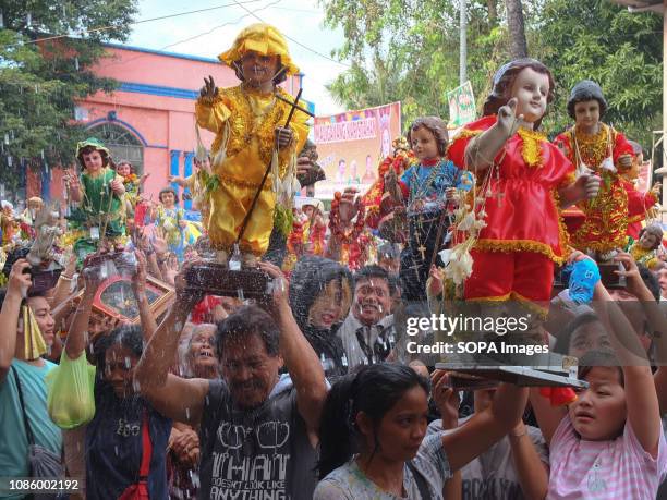 Catholic devotees soaked in holy water with their Sto. Niños during the Feast of the Sto. Niños in Tondo. Catholic Devotees bring their Sto. Niños to...