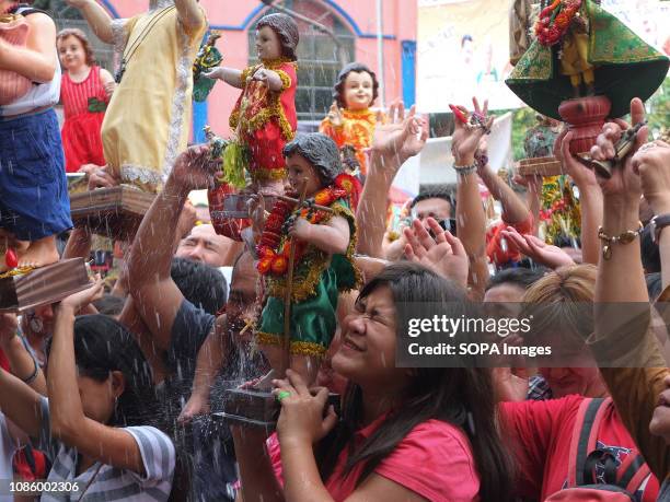 Catholic devotees soaked with holy water with their Sto. Niños during the Feast of the Sto. Niños in Tondo. Catholic Devotees bring their Sto. Niños...
