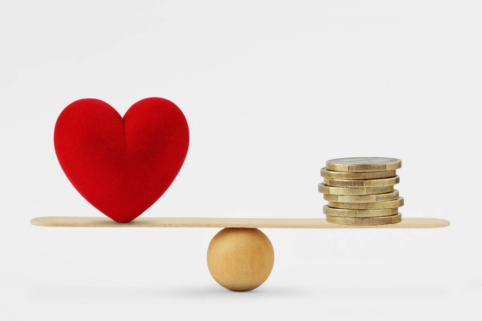 Heart and money on balance scale - Order of priority in life among love and money Heart and money on balance scale - Order of priority in life among love and money