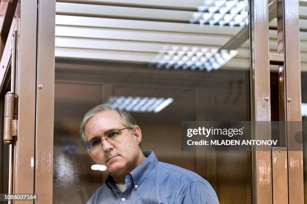 Paul Whelan, a former US Marine accused of espionage and arrested in Russia, stands inside a defendants' cage during a hearing at a court in Moscow...