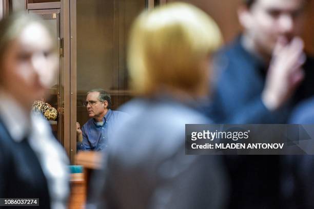 Paul Whelan, a former US Marine accused of espionage and arrested in Russia, speaks with his lawyers from inside a defendants' cage during a hearing...