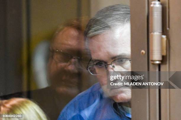 Paul Whelan, a former US Marine accused of espionage and arrested in Russia, speaks with his lawyers from inside a defendants' cage during a hearing...