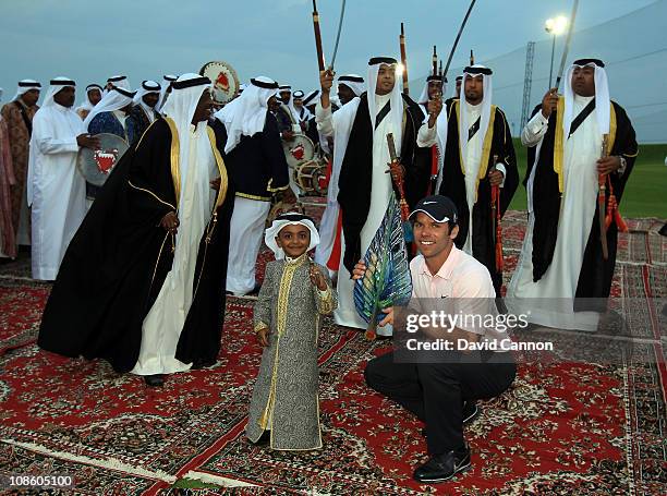 Paul Casey of England holds the trophy as a group of local tribal dancers perform after the final round of the 2011 Volvo Champions held at the Royal...