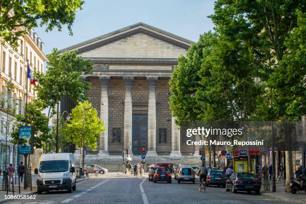 mensen lopen naast "l'église de la madeleine" (kerk van la madeleine) in de stad parijs, frankrijk. - church color light paris stockfoto's en -beelden