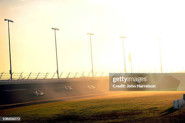 Cars race through turns three and four during The Rolex 24 at Daytona International Speedway on January 30, 2011 in Daytona Beach, Florida.