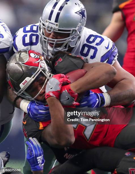 Antwaun Woods of the Dallas Cowboys tackles Jacquizz Rodgers of the Tampa Bay Buccaneers in the second quarter at AT&T Stadium on December 23, 2018...