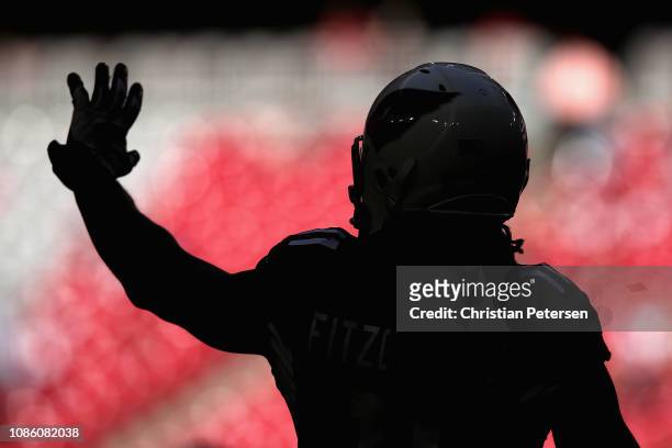 Wide receiver Larry Fitzgerald of the Arizona Cardinals waves as he warms-up before the NFL game against the Los Angeles Rams at State Farm Stadium...