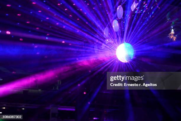 light beams reflecting from a disco ball - nightclub fotografías e imágenes de stock