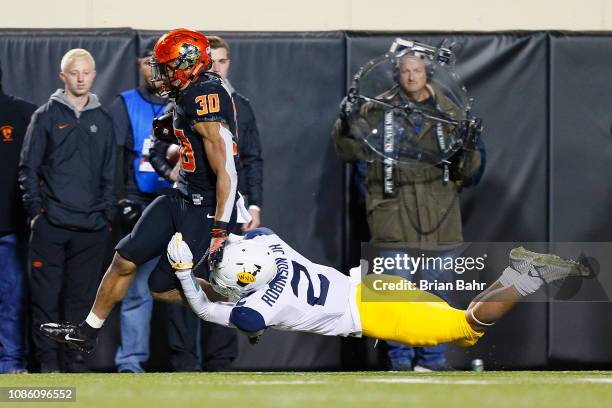 Running back Chuba Hubbard of the Oklahoma State Cowboys takes a catch up the sideline for a 14-yard gain against safety Kenny Robinson Jr. #2 of the...