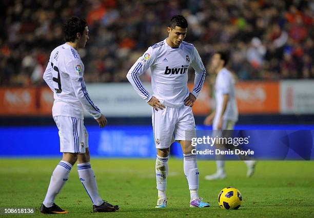 Cristiano Ronaldo of Real Madrid prepares to take a free kick next to team mate Mesut Ozil during the La Liga match between CA Osasuna and Real...