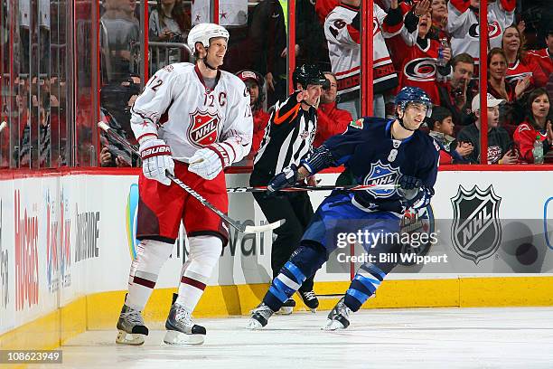 Eric Staal of the Carolina Hurricanes smiles after scoring a goal in the third period against Team Staal Brent Burns of the Minnesota Wild looks on...