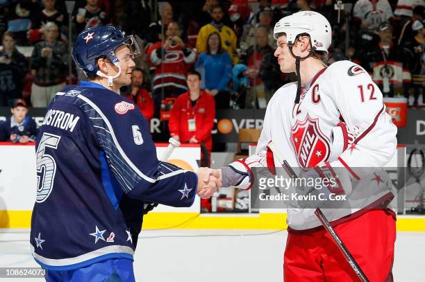 Team Lidstrom captain Nicklas Lidstrom of the Detroit Red Wings shakes hands with Team Staal captain Eric Staal of the Carolina Hurricanes after Team...