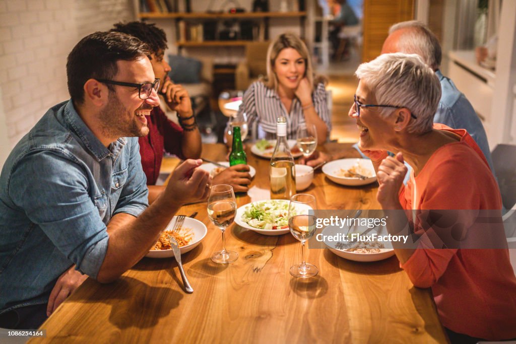 Mother and son chatting during dinner party