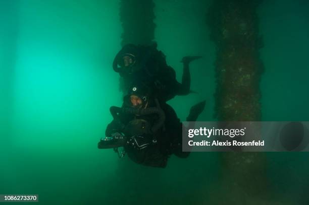 Two combat swimmers are moving through turbid waters, equipped with a pure oxygen FROG rebreather, during a training mission at the Commando Hubert...