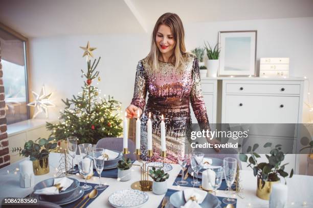 preparing for christmas dinner - woman in cocktail dress stock pictures, royalty-free photos & images