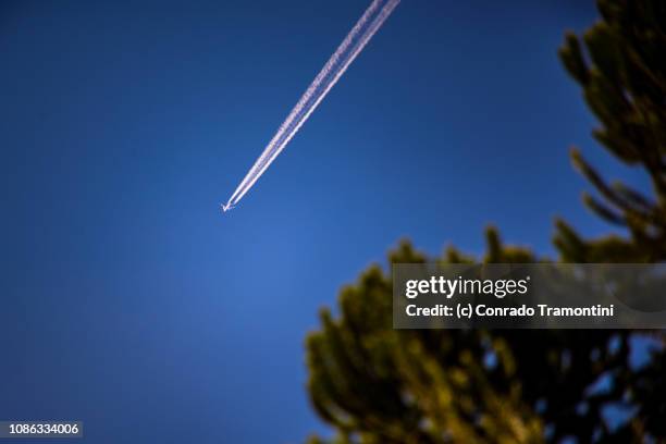 rastro de avião no céu azul - avião stock pictures, royalty-free photos & images