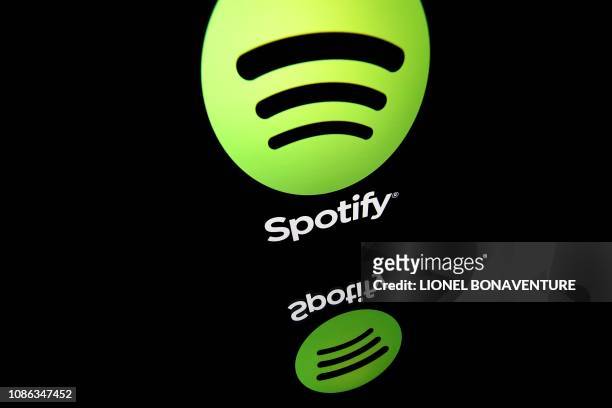 In this file photo illustration taken on April 19, 2018 shows the logo of online streaming music service Spotify displayed on a tablet screen in...