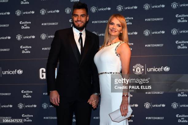 Manchester United's Argentinian goalkeeper Sergio Romero and his wife Eliana Guercio pose on the red carpet upon arrival to attend the "United for...