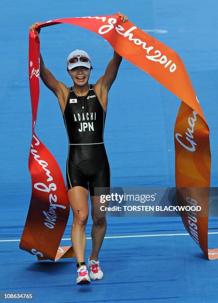 Mariko Adachi of Japan jubilates as she crosses the finish line of the woman's triathlon at the 16th Asian Games in Guangzhou on November 13, 2010....
