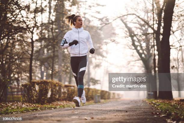 kvinna som jogging under vintermorgon - träningsutrustning sportutrustning bildbanksfoton och bilder