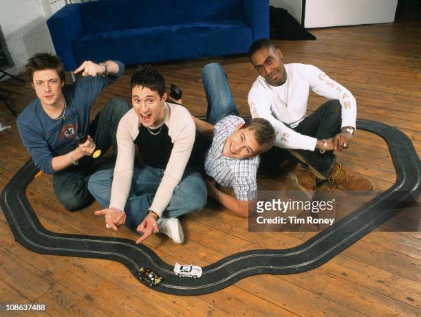 British boy band Blue with a model racing set, London, circa 2003. They are Simon Webbe, Lee Ryan, Duncan James and Antony Costa.