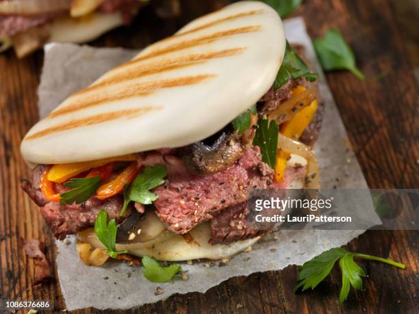steak and peppers on grilled bao buns - bao bun stock pictures, royalty-free photos & images