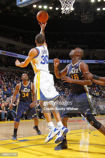 Stephen Curry of the Golden State Warriors attempts a reverse layup against Francisco Elson of the Utah Jazz on January 30, 2011 at Oracle Arena in...