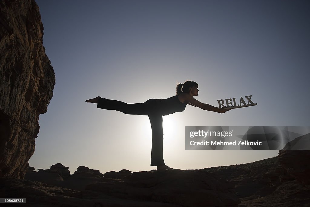 Sunset Yoga Worrior 3 pose with relax sign