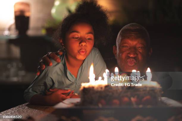 nipote che festeggia la festa di compleanno - african american grandparents foto e immagini stock