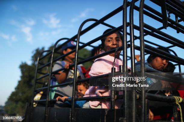 People from a caravan of Central American migrants wait to depart on a truck, whose driver offered a ride, on their way toward the United States, on...