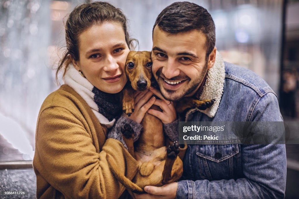 Retrato de pareja encantador y lindo perro marrón