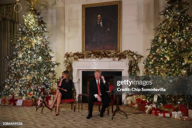 President Donald Trump and first lady Melania Trump take phone calls from children as they participates in tracking Santa Claus' movements with the...