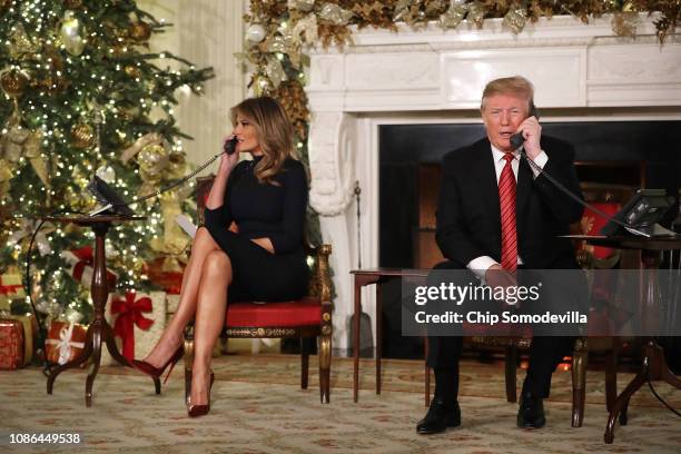 President Donald Trump and first lady Melania Trump take phone calls from children as they participates in tracking Santa Claus' movements with the...