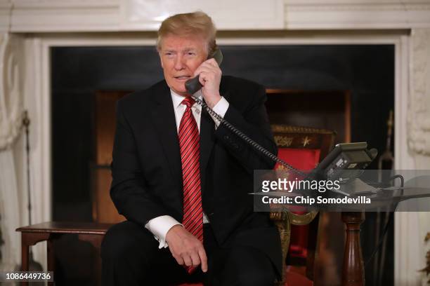 President Donald Trump takes phone calls from children as he participates in tracking Santa Claus' movements with the North American Aerospace...